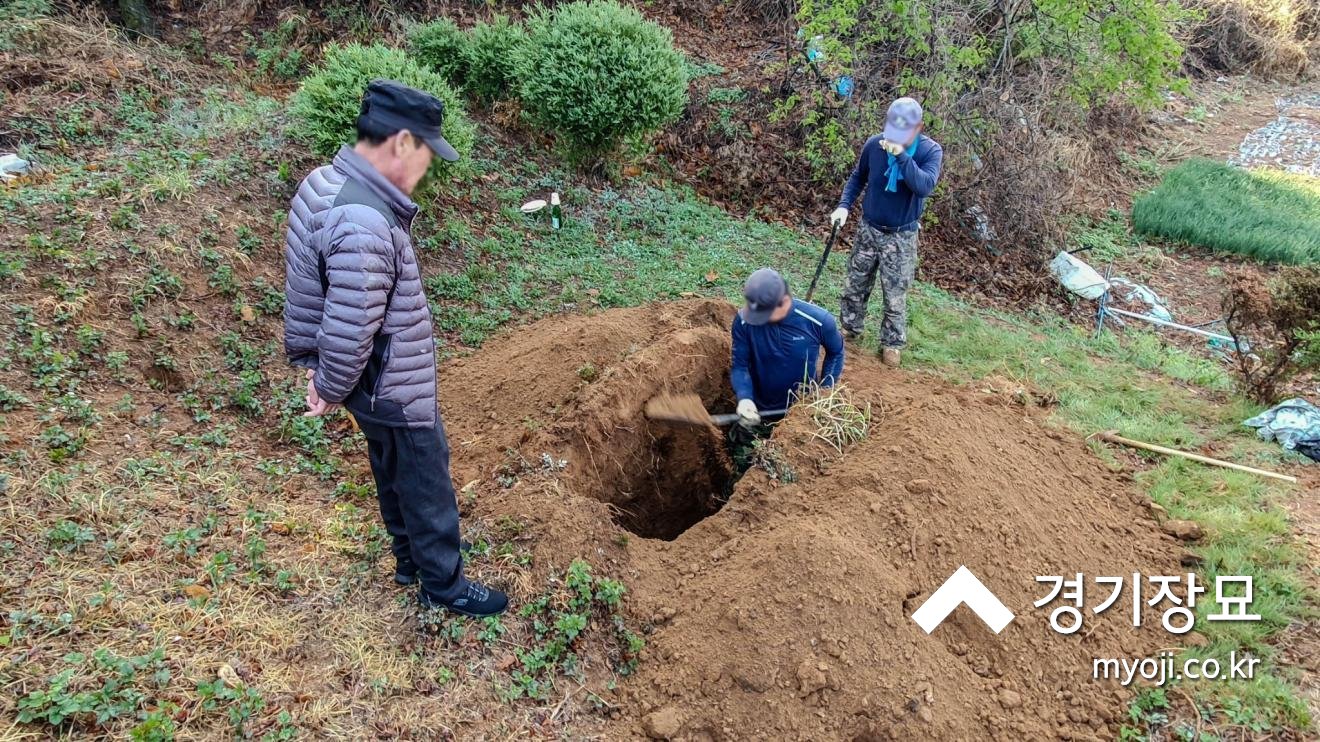 패딩 점퍼를 입은 유족과 광중에서 작업하는 모습